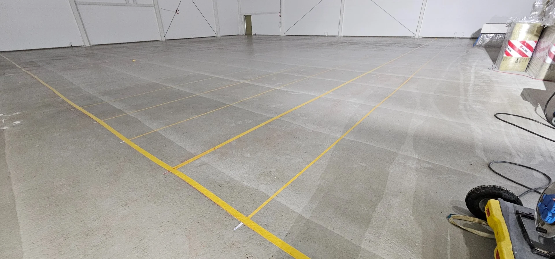 Hörslingans projekterade kabelmönster mäts ut och fixeras på betonggolvet i Mullhyttans sporthall