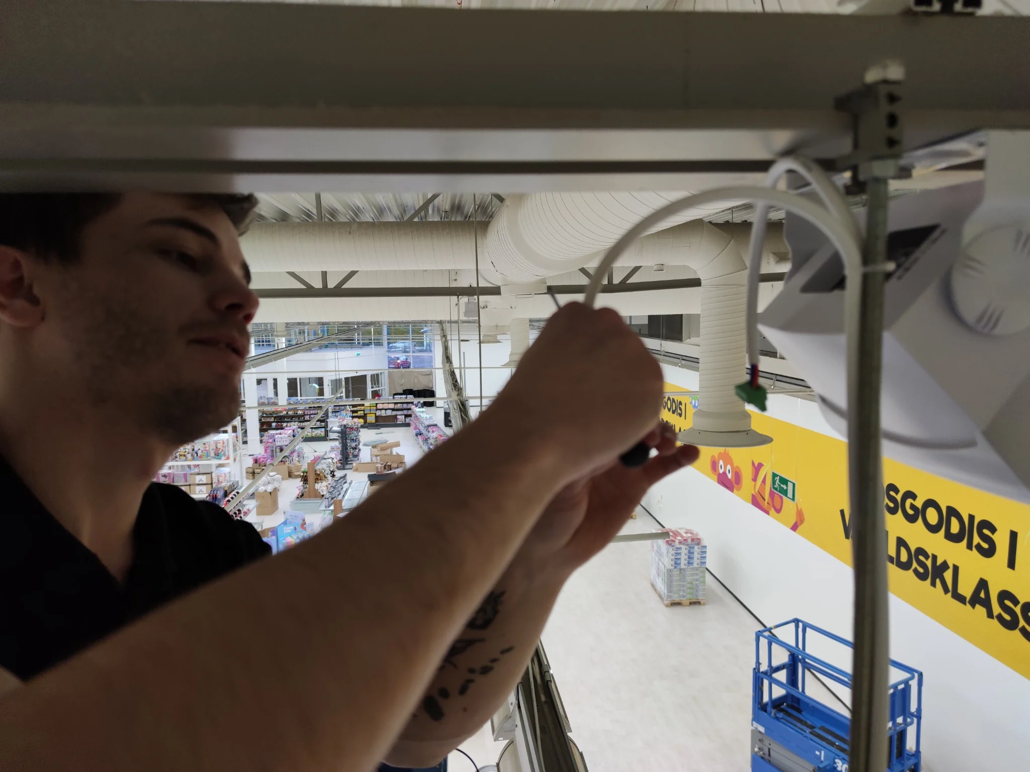 AVAB-tekniker installerar fisheye-kamera i taket hos Go Banana Bergvik